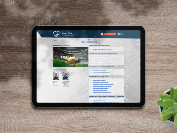 Image d'une tablette posée horizontalement sur une table en bois affichant un site web sportif nommé Ligue de Foot avec des sections telles que "Vie de l'association" et des vignettes pour les coordinateurs.